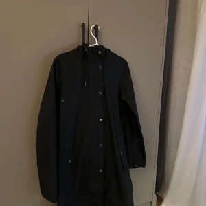 Svart regnjacka från Samsøe Samsøe - Säljer en stilren svart regnjacka från Samsøe Samsøe i storlek XS. Uppstripat ”styledbyme” på ryggen 