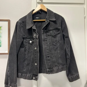 Svart/Grå jeansjacka från BikBok strl S - Säljer en snygg svart jeansjacka från BikBok i mycket bra skick. Jackan har en klassisk design med knappar framtill och två bröstfickor. Perfekt för höst och vår, och passar till nästan allt! 🖤 såljer då denna är för liten för mig