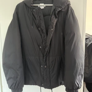 HOPE Puffer Jacket - HOPE jdunjacka i svart. Kostade originellt ca 4000kr. Lite oversized passform men inte överdrivet, passar mig som ligger runt M/L. Super skön jacka med kvalité. Använd knappt under en vintersäsong, så riktigt bra skick! Jackan har spännsnören för både luvan och runt midjan samt en innerficka.  (Storlek Male: 46 Woman: 38)