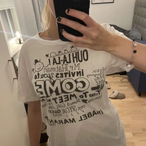 Vit t-shirt från Isabel Marant pour H&M - Säljer en vit t-shirt från Isabel Marant pour H&M med ett coolt tryck på framsidan. Den är kortärmad och i bra skick. Perfekt för en avslappnad stil eller att bära till vardags.