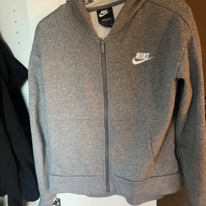 Grå hoodie från Nike - Säljer en grå hoodie från Nike i mycket bra skick. Storleken är i XL i barn men skulle säga att den är S/M i normalstorlek!