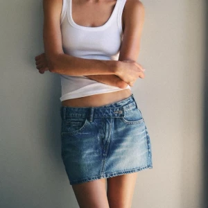 Jeanskjol i blå denim - Säljer en snygg jeanskjol i blå denim. Trendade mycket i sommar och slutsåld på Zaras hemsida. Den har en klassisk femficksdesign och en knapp framtill. Kjolen är i bra skick och passar till det mesta i garderoben. Använd en gång . 💙