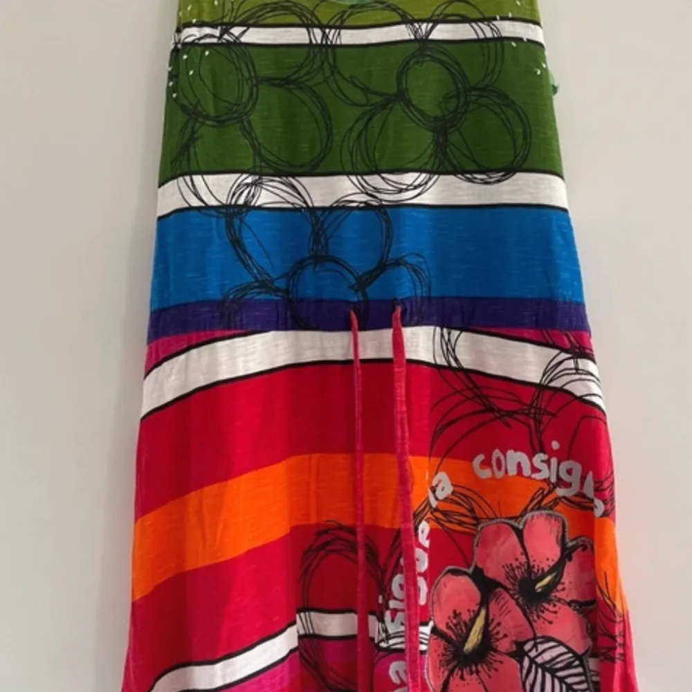 Säljer en superfin och färgglad klänning från Desigual i storlek CHILD L. Klänningen har ett unikt mönster med ränder i grönt, blått, rött och orange samt blommor. Perfekt för sommaren med sin lätta och luftiga stil. Den har en normal passform och är i mycket bra skick.. Klänningar.