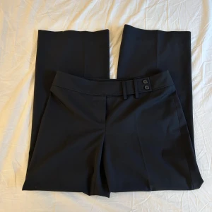 Svarta low-waist Marc Aurel kostymbyxor  - Säljer mina ur snygga Marc Aurel kostymbyxor i strl 38, dom är lite wide till straight passform och är så sköna. Ytterben: 96cm innerben är 70cm midjemått tvärs över: 40cm