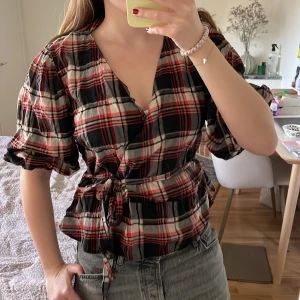 Rutig topp - Cool rutig topp med puffärmar!! Storlek 42, men passar mig som brukar ha 38 eftersom man kan knyta den!