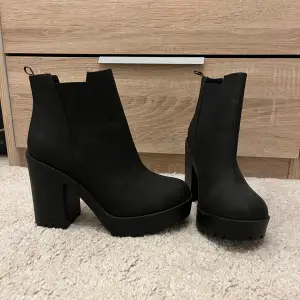 Snygga svarta boots med hög klack och grov sula. Perfekta för höst och vinter, dessa boots har en stilren design utan snörning eller dragkedja. De är både bekväma och trendiga, idealiska för att lyfta vilken outfit som helst. Passar perfekt till både vardag och fest! Aldrig använda!!!!