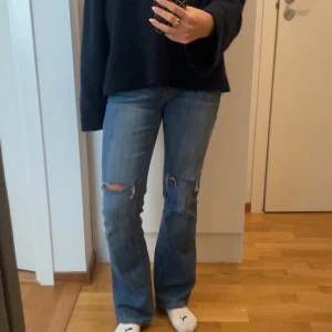 Low waist bootcut jeans med slitningar - Säljer ett par snygga blå Low waist bootcut jeans i bra skick. De har coola slitningar/hål på knäna och snygga fickor, köpta vintage ❤️inga andra defekter , mått 39 midja och 81 innerbenslängd