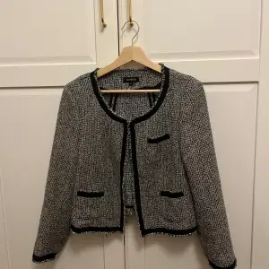 Säljer en svartvit kavaj från Lindex i storlek 42. Den har en tweed-look. Kavajen är i mycket bra skick. Storlek 42 men skulle säga att den passar 38/40/42.