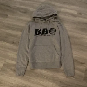 Grå hoodie från Billionaire Boys Club - Säljer en snygg grå hoodie från Billionaire Boys Club. Den har en stor ficka fram och ett coolt tryck med BB-loggan på bröstet. Perfekt för en avslappnad stil och passar till alla tillfällen. Grymt skön och stilren! Pris kan diskuteras 