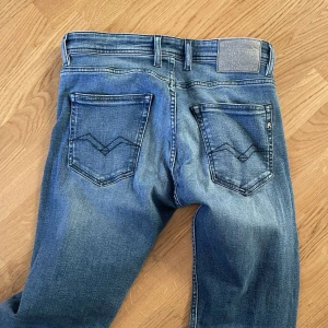 Blå jeans från Replay - Säljer ett par snygga blå jeans från Replay i storlek 30. De har en klassisk femficksdesign med en cool tvättad look. Perfekta för både vardag och fest! 🕺