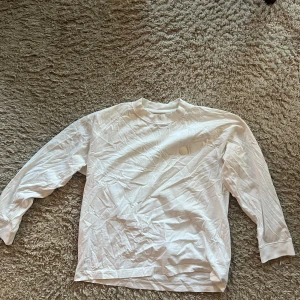 Acne studios långärmad t-shirt - Vit långärmad t-shirt från Acne Studios. T-shirten har en rund halsringning och en rak passform. Den har en liten logotyp på bröstet och en större logotyp på baksidan.  Storlek S men oversized och passar mer en stor M, sitter perfekt på mig som är 175cm 75kg.  Skrynklig efter att ha legat i garderoben men i fint skick, sparsamt använd.  Hälsningar//  Ludvig 