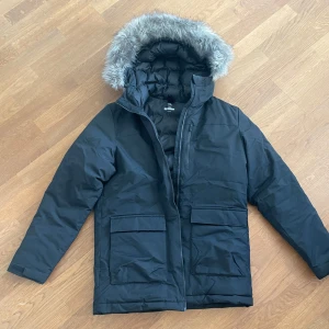 Svart vinterjacka från Adidas stl M - Säljer en snygg svart vinterjacka från Adidas i mycket bra skick. Stl M Jackan har en mysig pälskantad huva och praktiska fickor framtill. Perfekt för kalla vinterdagar! 🖤