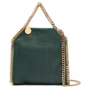 Grön väska från Stella McCartney - Säljer en snygg grön väska från Stella McCartney med guldfärgade kedjedetaljer. Väskans enda defekt är att kedjan för man håller har börjat förlora sin färg, dock inget man ser från långt håll eller när man håller i väskan. Äktighets bevis och dust bag medföljer. Kan sänka pris vid köp direkt⭐️😇😇