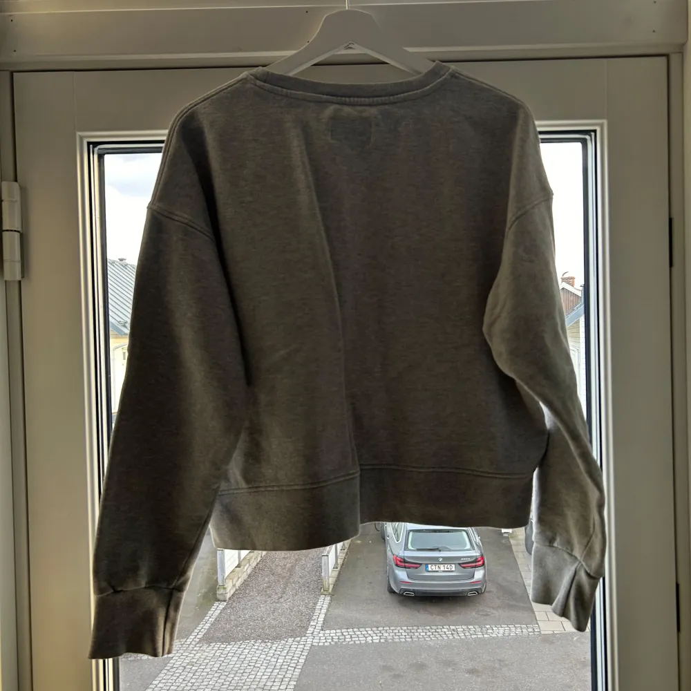 Säljer en snygg grå sweatshirt från Nørgaard med tryck på framsidan. Tröjan är i bra skick och perfekt för en avslappnad stil. Den har långa ärmar och en bekväm passform. Perfekt för höst och vår!. Tröjor & Koftor.