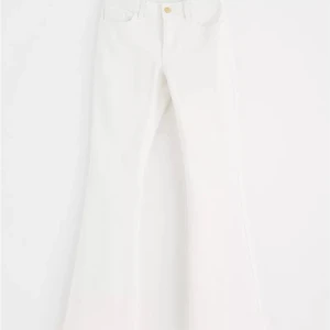 Vita bootcut jeans - Säljer ett par snygga vita bootcut jeans. De är högmidjade och har en klassisk femficksdesign med knappar fram. Perfekta för både vardag och fest!
