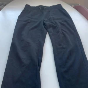 Svarta mjukisbyxor med snörning - Säljer ett par svarta mjukisbyxor i bra skick. De har en bekväm elastisk midja med snörning och praktiska fickor fram. Perfekta för en avslappnad dag hemma eller en promenad i parken. Passar till det mesta och är supermjuka!