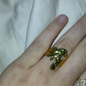 Unik guldpläterad ring - Säljer en supercool och unik guldpläterad ring med en abstrakt, vågig design. Den har en glänsande yta som verkligen fångar ljuset. Perfekt för att ge din outfit en extra touch av stil och elegans. Passar både till vardags och fest!