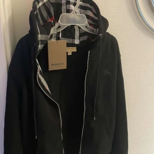 Svart hoodie från Burberry - Säljer en snygg svart hoodie från Burberry i storlek L men passar också till M. Den är i ny skick. Vid snabb affär k av priset diskuteras.