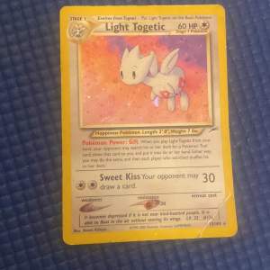 Säljer ett Light Togetic Pokémon-kort från Neo Destiny-serien. Kortet har en glittrig yta och är i bra skick med några tecken på slitage. Perfekt för samlare eller Pokémon-entusiaster! 🌟