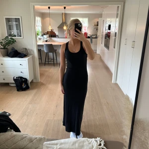 Svart långklänning från ONLY - Säljer en stilren svart långklänning från ONLY i storlek M. Klänningen är ärmlös och har en tight passform som framhäver figuren. Perfekt för både vardag och festliga tillfällen. Materialet är mjukt och bekvämt, vilket gör den skön att bära hela dagen.