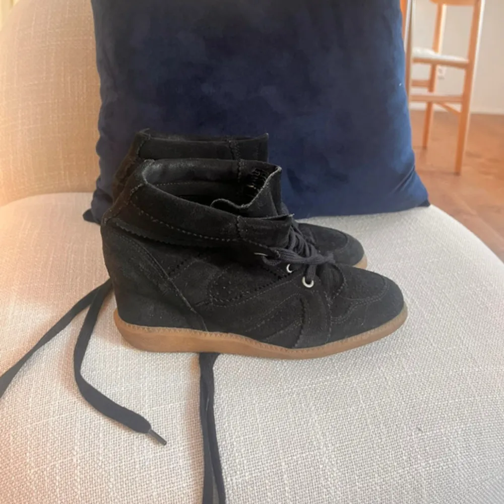 Säljer ett par svarta sneakers i mocka som liknar isabel marant med kilklack och snörning. De har en snygg och bekväm design med en gummisula som ger bra grepp. Perfekta för både vardag och festliga tillfällen!🩶🩶. Skor.