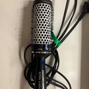 Rundborste med värme från Björn Axén - Säljer en rundborste med integrerat värmesystem från Björn Axén. Den har keramisk och turmalinbeläggning för skonsam styling och en sladd för enkel användning. Perfekt för att skapa volym och lockar i håret. Använd ett par gånger men i bra skick.