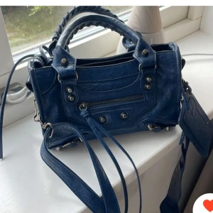 Blå axelväska med dragkedja - Säljer en snygg blå axelväska i skinn med coola detaljer. Väskan har en praktisk dragkedja och en justerbar axelrem. Perfekt för både vardag och fest! 👜✨