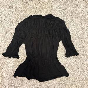 Svart blus med volangdetaljer - Jättesöt blus/topp med trekvartsärmar som är för stor på mig. Hör av er vid fler frågor och bilder💞