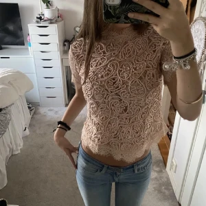 Ljusrosa spetströja - Säljer en superfin rosa spetsblus från Zara med korta ärmar och volangdetaljer. Perfekt för vardag eller en fest. Den är i mycket bra skick, skriv för mer bilder!💕