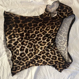 Leopardmönstrad topp med spetsdetaljer - Säljer en snygg leopardmönstrad topp med korta ärmar och spetsdetaljer som knappt är använd, liknar den från Nelly.Toppen har en liten rosett framtill och är perfekt för en utekväll eller fest. Materialet är mjukt och stretchigt för en bekväm passform.