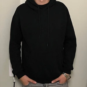 Svart hoodie från Jack & Jones - Säljer en stilren svart hoodie från Jack & Jones Core. Hoodien har en klassisk design. Passar till det mesta och är superbekväm!