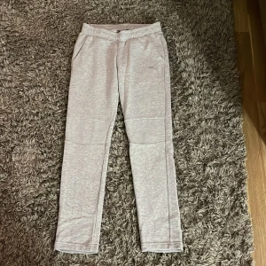 Grå mjukisbyxor från Puma - Säljer ett par grå mjukisbyxor från Puma i storlek XS. De är superbekväma och perfekta för en avslappnad dag hemma eller lätt träning. Byxorna har en elastisk midja och är gjorda i mjukt material för extra komfort. Låg midja de❤️