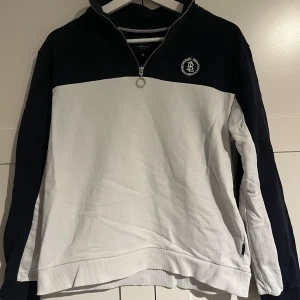 Bondelid reggie half zip - Hej säljer min Bondelid reggie half zip som är vit och marinblå. Med storleken barn M det finns en lite fläck på den men annars är den felfri från skador