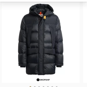 Svart dunjacka från Parajumpers - Säljer en svart dunjacka från Parajumpers i mycket bra skick. Jackan har en pufferstil med lång ärm och en praktisk huva. Den är perfekt för kalla vinterdagar och har en snygg patch på ärmen. Dragkedja framtill med en gul detalj som ger en cool kontrast.