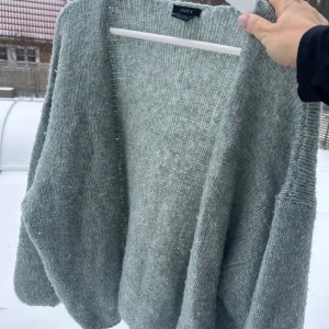 Grön stickad kofta från Lindex - Mysig grågrön stickad kofta från Lindex i storlek M/L. Perfekt för kyliga höst- och vinterdagar. Den har en enkel och stilren design med långa ärmar och en öppen front. Superbekväm och lätt att matcha med olika outfits. Ett måste i garderoben för alla som älskar lager på lager! 🍂 svårt att få en rättvis bild på den ljusgröna färgen.