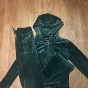 Grön velour hoodie från Juicy Couture - Säljer en supermjuk och snygg grön velour hoodie från Juicy Couture. Den har en dragkedja framtill och en klassisk luva. Perfekt för en chill dag hemma eller en avslappnad utflykt. Den är i mycket bra skick och redo för en ny ägare!