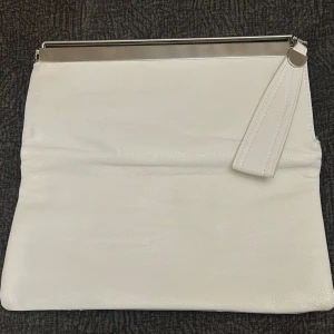 Handväska  - Säljer nu min vita handväska som jag endast använt 3 gånger, den har jätte fint ljusblått sile som innefoder och passar perfekt till utelvällar. Du kan had den både ihopvikt eller som den är.   