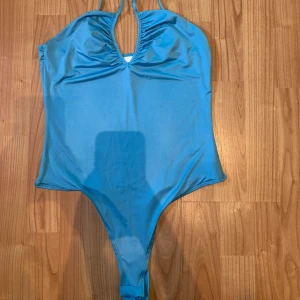 Blå body - Blå body från H&M i storlek S. Använd max 3 ggr och med skydd/trosor till nedre delen. Smått flockig på några ställen men syns inte från avstånd. Går att spänna in axelbanden. 
