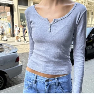 Grå långärmad topp - Säljer en  grå långärmad topp med knappar framtill och är lite croppad