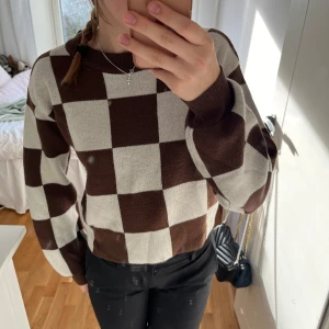 Stickad rutig tröja - Stickad rutig tröja i vitt och brunt. Bra skick och använd flertals gånger.  Lite nopprig men knappt.