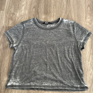 Grå t-shirt från Bik Bok - Säljer en enkel och stilren grå t-shirt från Bik Bok. Den har en normal passform och är tillverkad i mjukt bomullsmaterial. Perfekt för vardagsbruk och kan matchas med nästan vad som helst. Ett måste i garderoben!