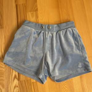 Säljer ett par superbekväma blå shorts från Juicy Couture. De är i mjukt material med en elastisk midja och en liten ficka bak. Perfekta för en avslappnad dag eller sommaren. Storlek, 10-11 år. 