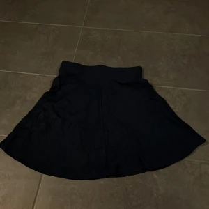 Marinblå kjol från Esprit - Säljer en stilren marinblå kjol från Esprit i storlek S. Kjolen har en klassisk design som passar perfekt för både vardag och fest. Den är i bra skick och har en bekväm passform. Perfekt att matcha med en snygg topp eller blus!