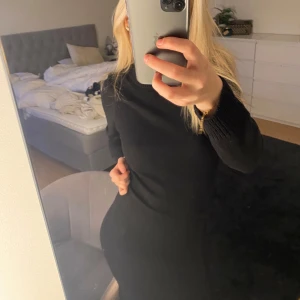 Svart långärmad klänning - Säljer en elegant svart långärmad klänning i mycket bra skick. Den har en tight passform som framhäver figuren och är perfekt för höst och vinter. Klänningen är gjord av ett mjukt och bekvämt material, vilket gör den idealisk för både vardag och festliga tillfällen.