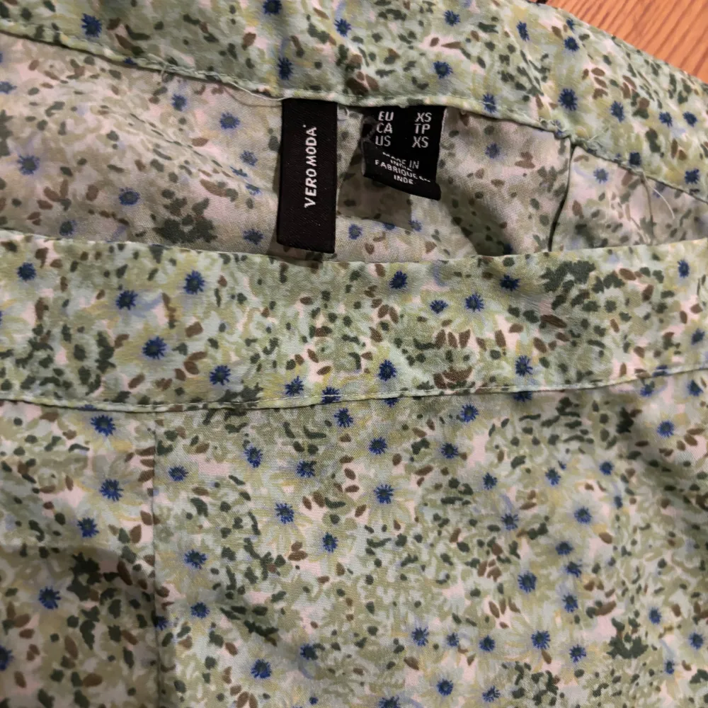 Superfin grön blommig kjol från Vero Moda i storlek XS. Kjolen har ett omlottmönster med volangdetaljer och är perfekt för vår och sommar. Den är gjord i ett lätt och luftigt material, vilket gör den bekväm att bära hela dagen. Perfekt för både vardag och festliga tillfällen! 🌸. Kjolar.