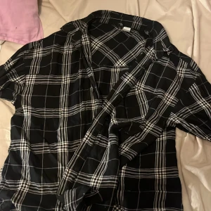 Svart och vit rutig skjorta - Säljer en snygg svart och vit rutig skjorta i storlek S. 