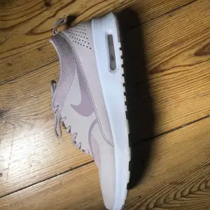 Säljer ett par snygga beige Nike sneakers i mycket bra skick. De har en stilren design med snörning och en bekväm sula. Perfekta för både vardag och träning. Passar till det mesta och ger en sportig touch till din outfit.