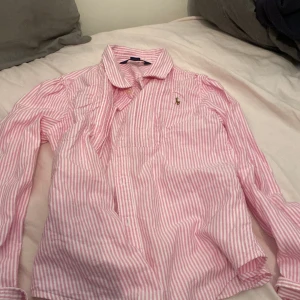 Polo skjorta - En rosa vit polo skjorta skick 9/10 nästan aldrig använd. Strl 12