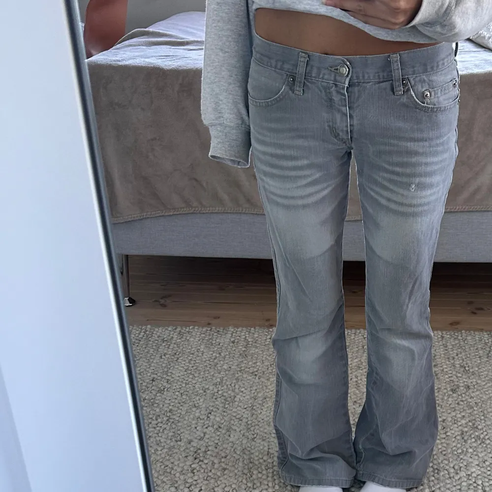 Ljusgrå lågmidjade bootcut jeans. Liten slitning på baksidan (bild 4) , men syns inte alls.  Midjemått 35cm, innerbenslängd 76cm💘. Jeans & Byxor.