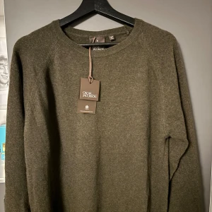 Oscar Jacobson Stickad Tröja. - En väldigt fin och skön stickad tröja från Oscar Jacobson i färgen Forest Bark. 80% ull & 20% polyamid. Aldrig använd (endast testad) och lapparna sitter kvar på plagget! Nypris ligger på 1400kr. Tveka inte på att höra dig vid minsta lilla fundering!